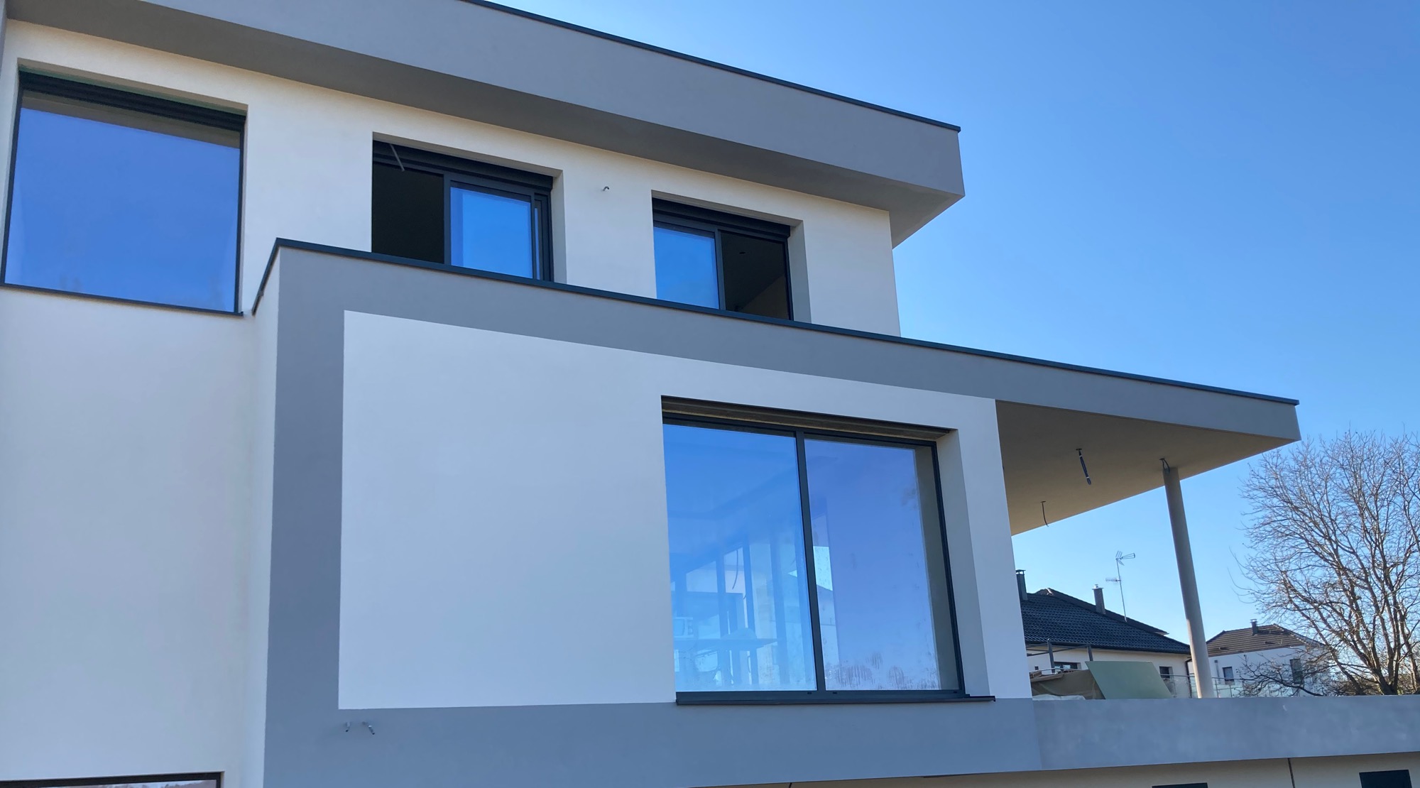 Façade contemporaine avec grandes baies et porte-à-faux à Leymen
